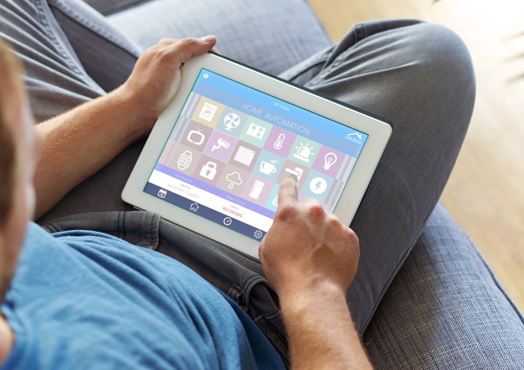 Man using a tablet to control home appliances