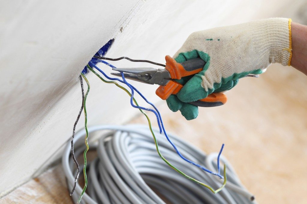 Electrician fixing wires on the wall