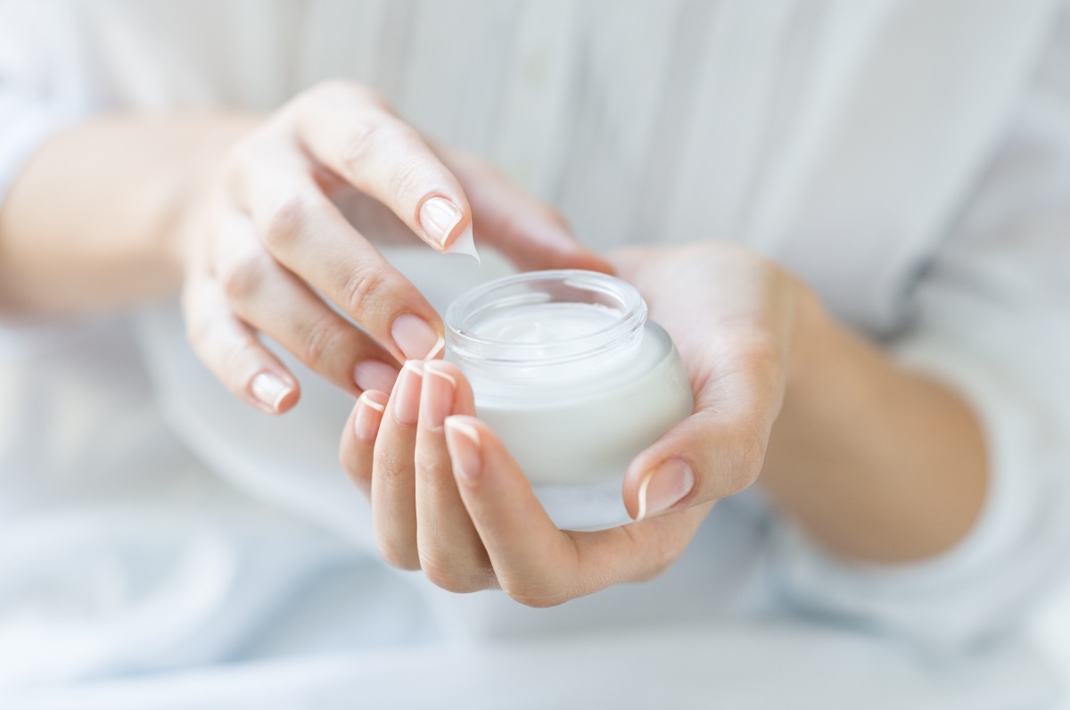 Woman holding moisturizing cream.