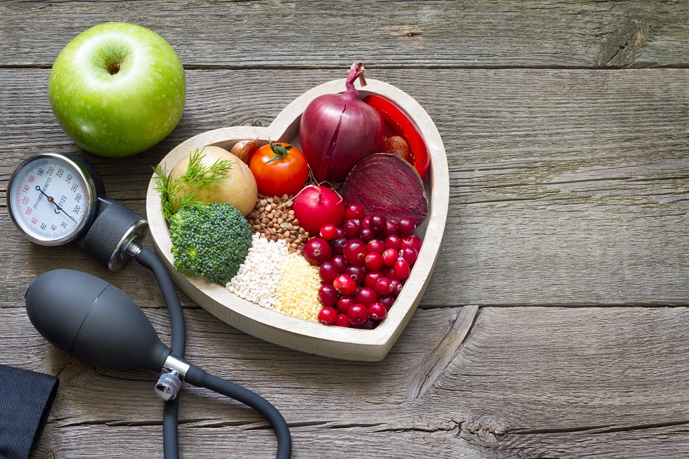 blood pressure pump next to heart shaped bowl with food