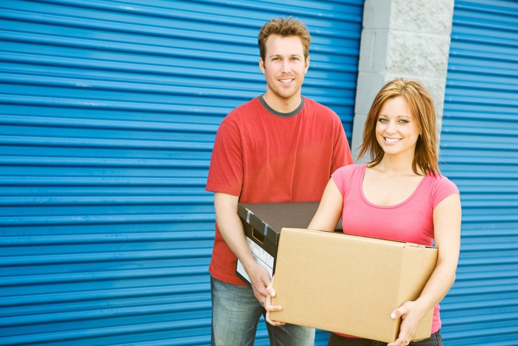 couple carrying boxes for storage