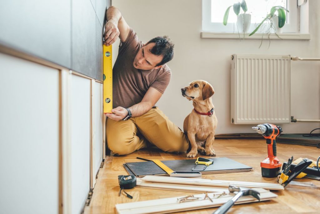 man renovating home with his dog