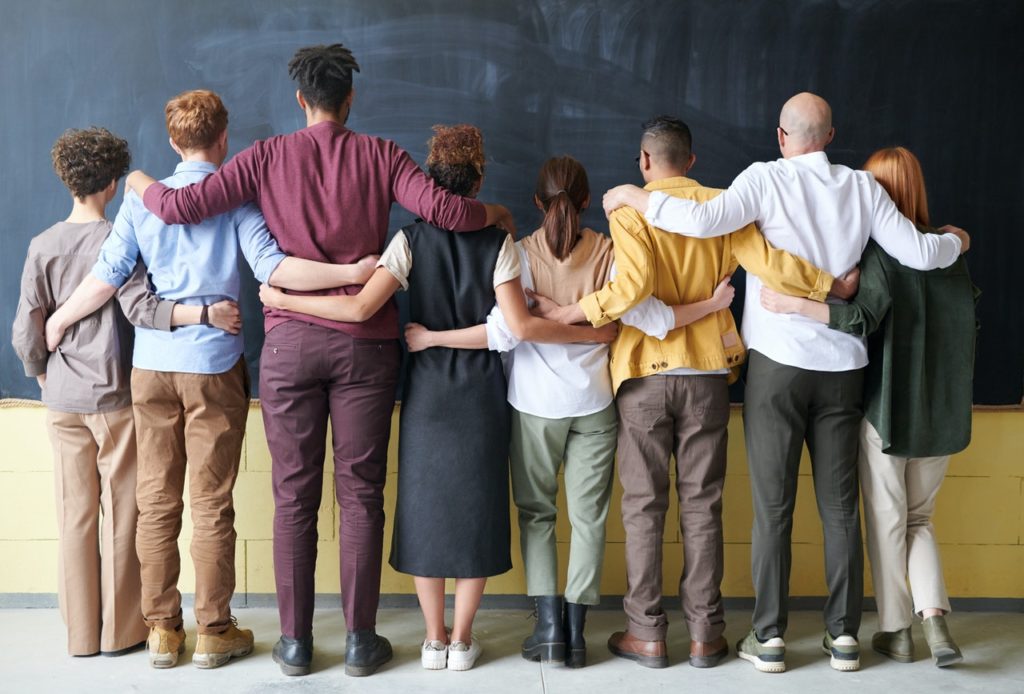 diverse group of people facing chalk board