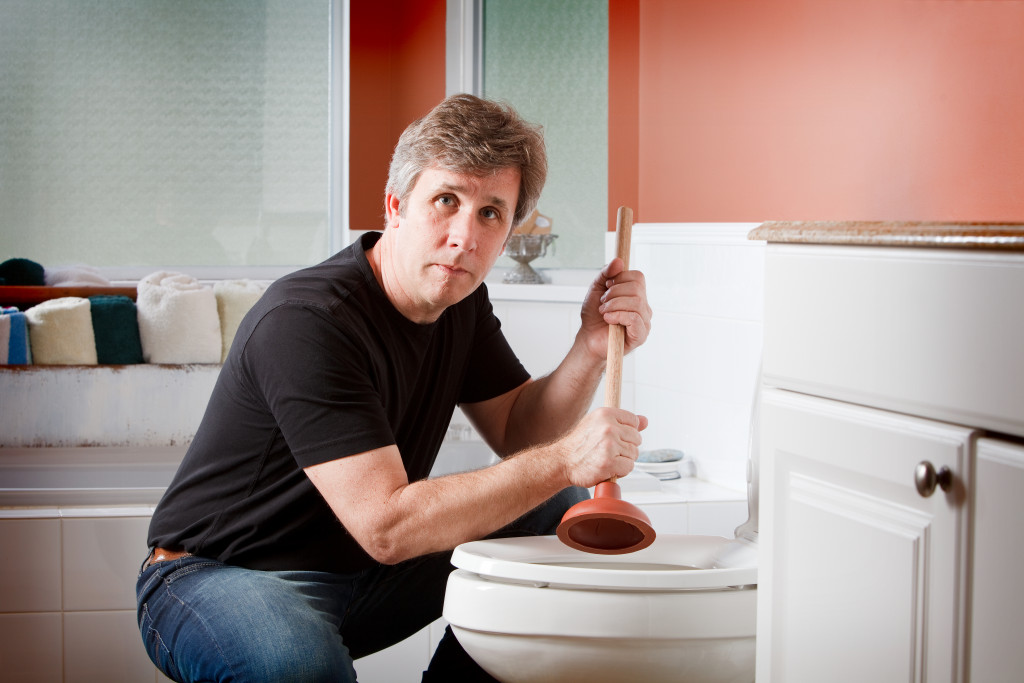 A man unclogging his toilet