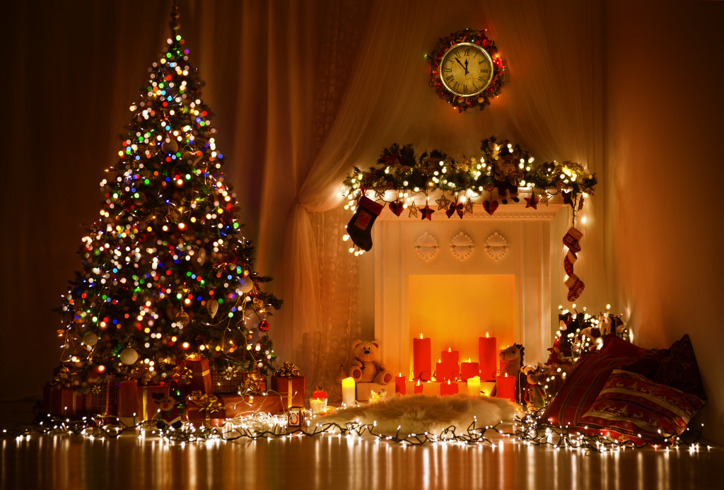A Christmas tree and fireplace decorated with candles and lights