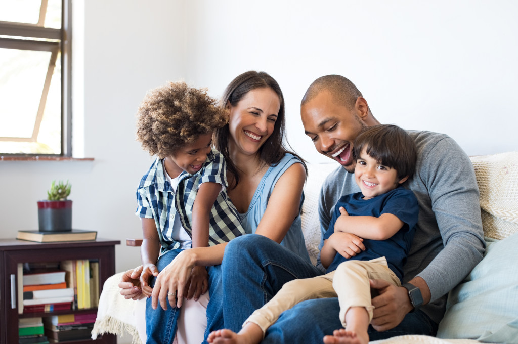 happy multiracial family sitting in sofa