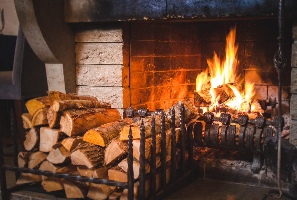 a fireplace with chirps of wood in front of it